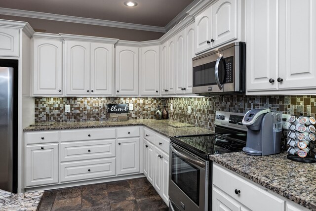 kitchen with appliances with stainless steel finishes, ornamental molding, white cabinets, stone counters, and decorative backsplash