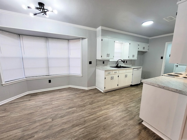 1907 Sunset, Pine Bluff, AR 71603 - kitchen featuring a sink, white dishwasher, dark wood finished floors, light countertops, and ornamental molding