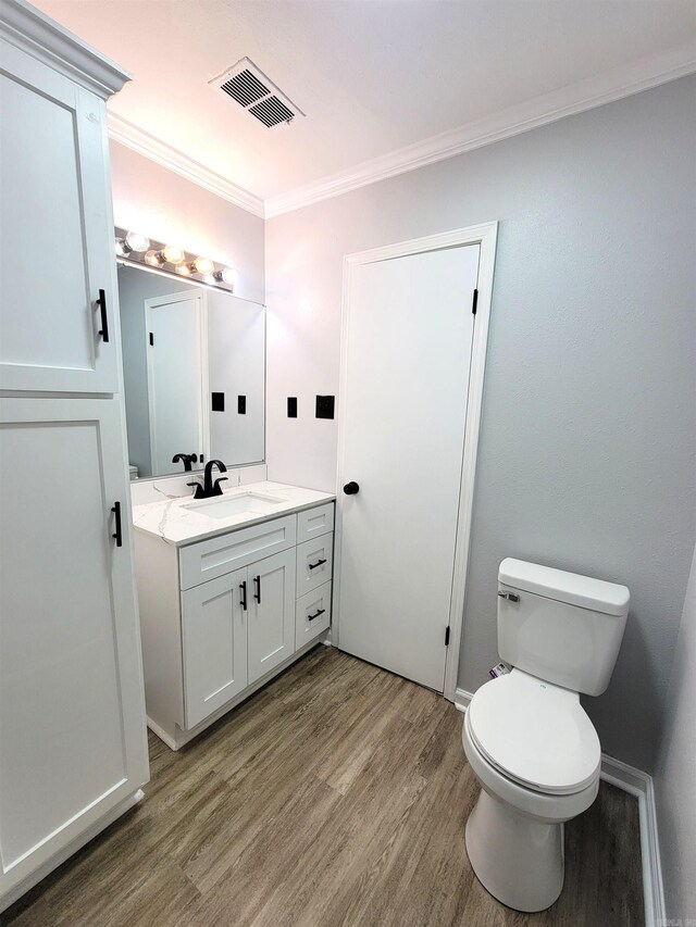 1907 Sunset, Pine Bluff, AR 71603 - bathroom with wood finished floors, vanity, crown molding, and toilet