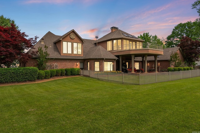 852 Rock Ledge Rd, Heber Springs, AR 72543 - back of property at dusk with brick siding, a balcony, and a shingled roof