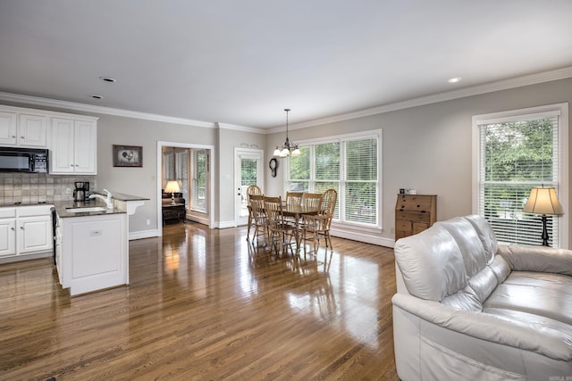 6 Frecourt Ln, Little Rock, AR 72223 - living area featuring a chandelier, dark wood-style floors, crown molding, and baseboards