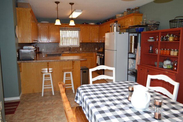 1059 Piney Rd, De Queen, AR 71832 - kitchen featuring freestanding refrigerator, a sink, a peninsula, gas range, and backsplash
