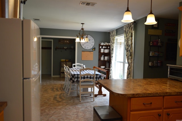 1059 Piney Rd, De Queen, AR 71832 - kitchen with freestanding refrigerator, a chandelier, pendant lighting, and dark countertops