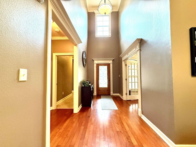 14 Windrush Pt, Little Rock, AR 72211 - foyer entrance featuring wood-type flooring, baseboards, a textured wall, crown molding, and a high ceiling