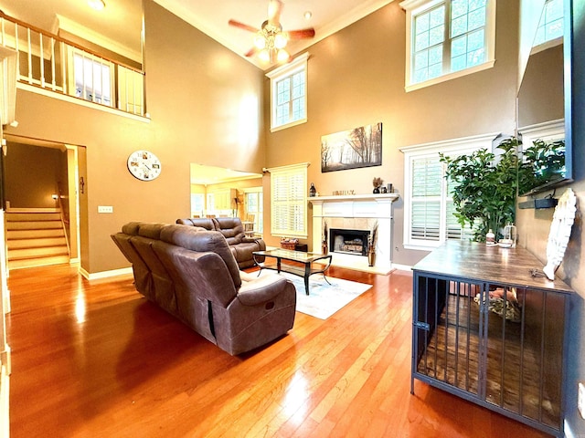 14 Windrush Pt, Little Rock, AR 72211 - living room with a towering ceiling, ceiling fan, a fireplace, wood finished floors, and baseboards