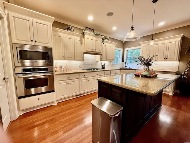 14 Windrush Pt, Little Rock, AR 72211 - kitchen with appliances with stainless steel finishes, a sink, crown molding, light wood-style floors, and backsplash