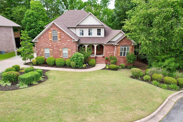14 Windrush Pt, Little Rock, AR 72211 - traditional-style house featuring brick siding, roof with shingles, a porch, and a front yard