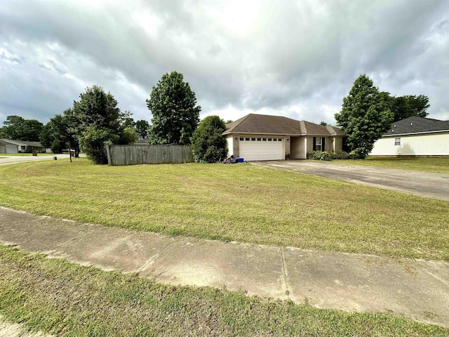 view of yard with an attached garage and asphalt driveway