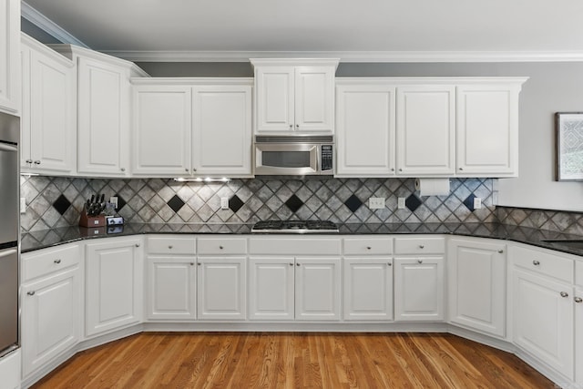 15 Challain Cv, Little Rock, AR 72223 - kitchen featuring stainless steel appliances, dark countertops, white cabinetry, light wood-style flooring, and backsplash