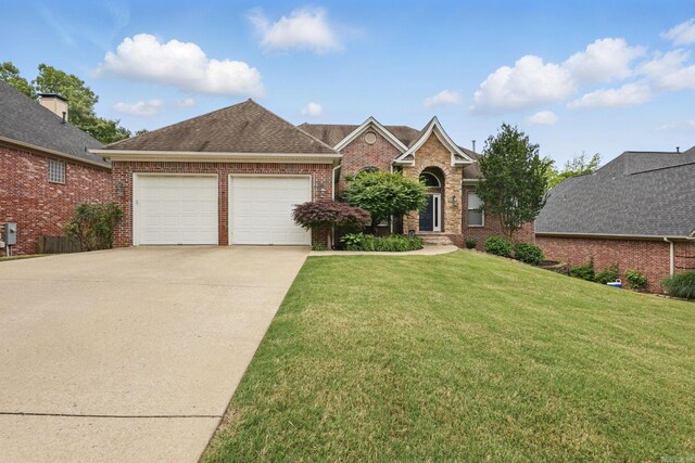 15 Challain Cv, Little Rock, AR 72223 - traditional home featuring an attached garage, driveway, a front yard, and brick siding