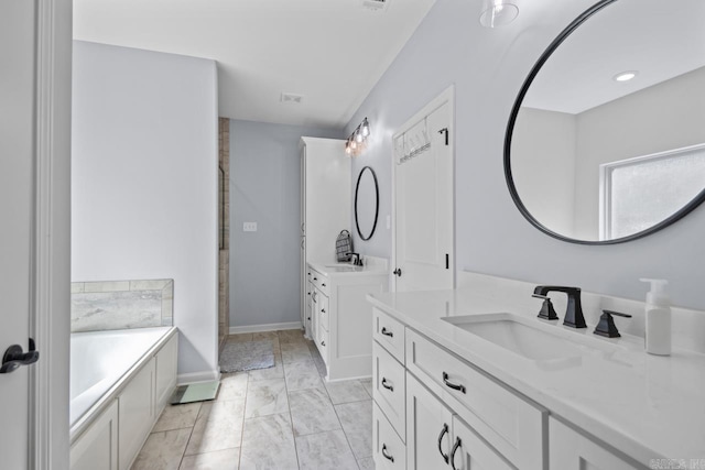 7841 S Shoreline Blvd, Benton, AR 72019 - full bath featuring two vanities, marble look tiles, a garden tub, and baseboards