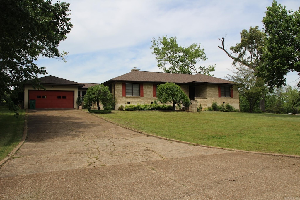 323 N 1st St, Flippin, AR 72634 - single story home featuring concrete driveway, an attached garage, a front lawn, and brick siding