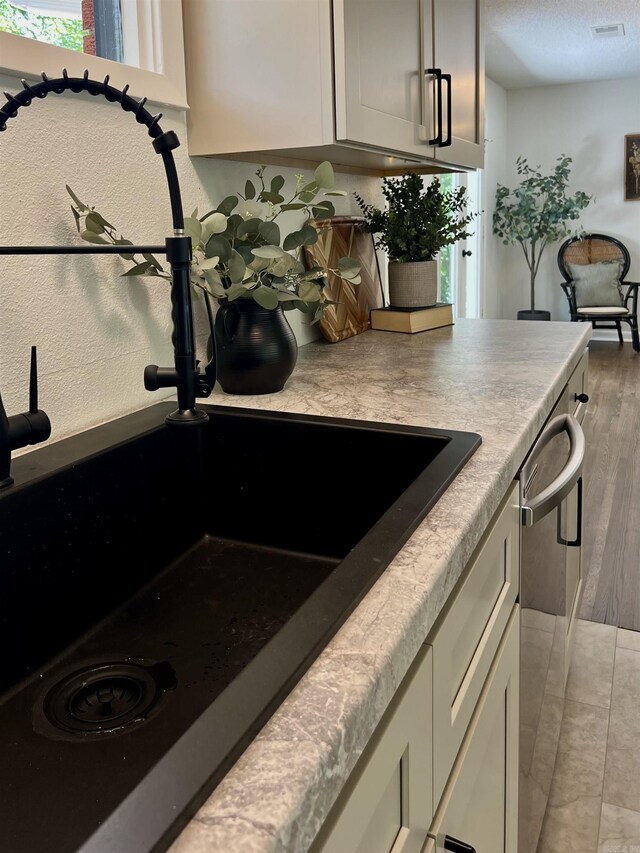 506 W Clinton St, Heber Springs, AR 72543 - kitchen view of dishwasher, a sink, light countertops, and light wood finished floors