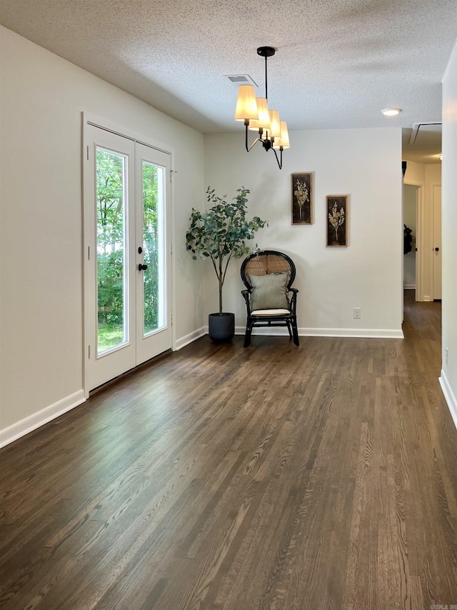 506 W Clinton St, Heber Springs, AR 72543 - unfurnished dining area featuring dark wood-style flooring, a textured ceiling, baseboards, a chandelier, and french doors
