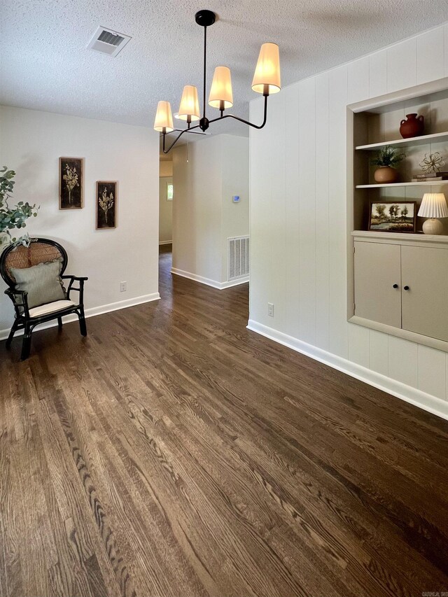 506 W Clinton St, Heber Springs, AR 72543 - unfurnished dining area with dark wood-style floors, a chandelier, a textured ceiling, and baseboards