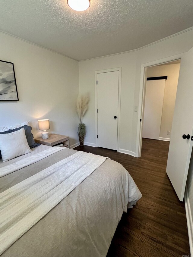 506 W Clinton St, Heber Springs, AR 72543 - bedroom with dark wood-style floors, a textured ceiling, and baseboards