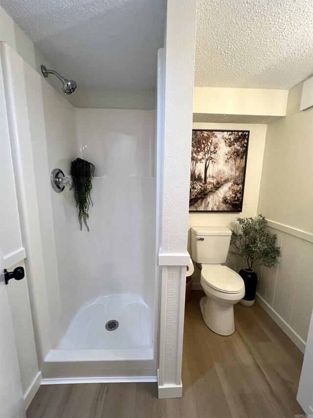 506 W Clinton St, Heber Springs, AR 72543 - full bathroom with a textured ceiling, a stall shower, wood finished floors, and toilet
