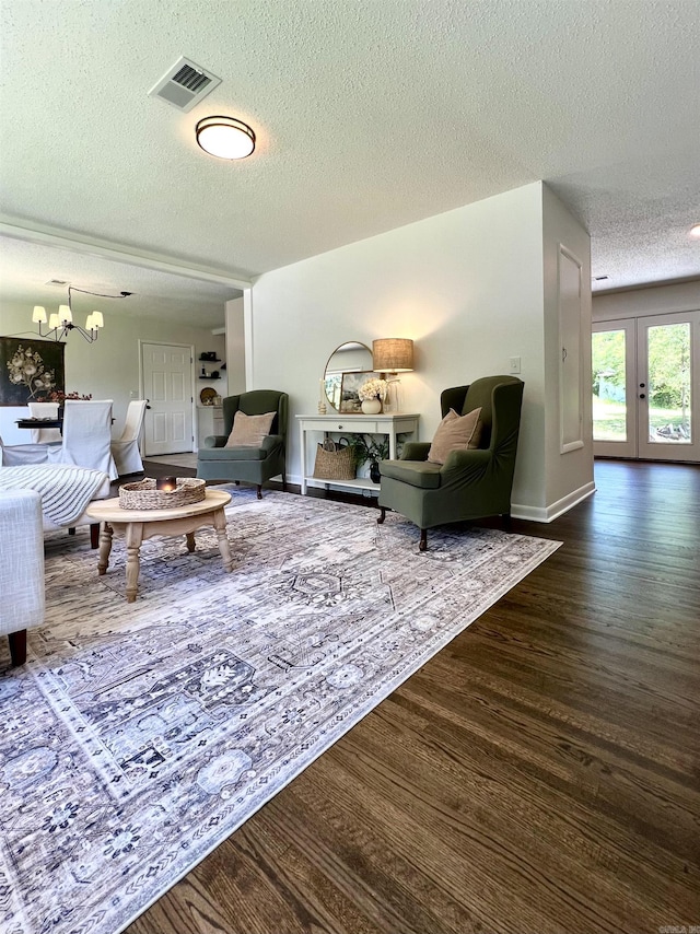 506 W Clinton St, Heber Springs, AR 72543 - living area featuring a textured ceiling, wood finished floors, french doors, a chandelier, and baseboards