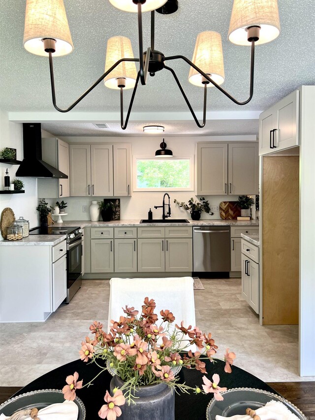 506 W Clinton St, Heber Springs, AR 72543 - kitchen with appliances with stainless steel finishes, wall chimney range hood, a sink, light countertops, and decorative light fixtures