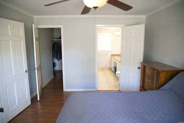 510 Frances, Magnolia, AR 71753 - bedroom featuring crown molding, a spacious closet, ensuite bathroom, wood finished floors, and a closet