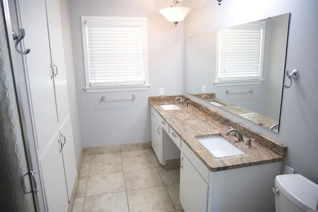 510 Frances, Magnolia, AR 71753 - full bath with toilet, baseboards, double vanity, tile patterned floors, and plenty of natural light