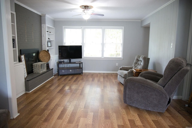 510 Frances, Magnolia, AR 71753 - sitting room featuring crown molding, ceiling fan, wood finished floors, baseboards, and a fireplace