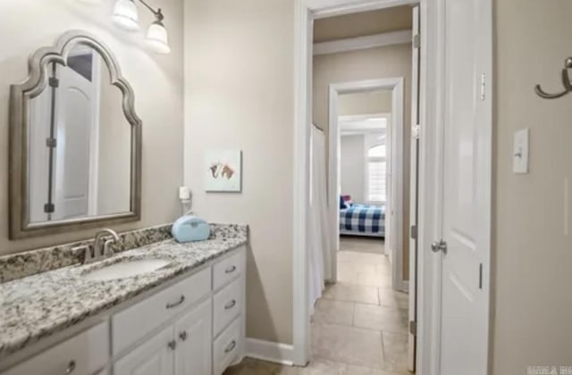 bathroom with baseboards, vanity, and tile patterned flooring