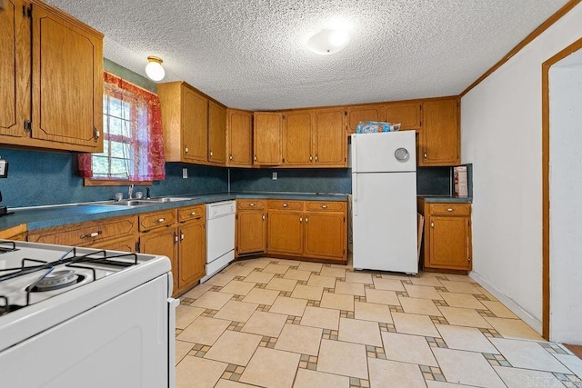 135 Cress Ln, Clinton, AR 72031 - kitchen with white appliances, a sink, brown cabinetry, a textured ceiling, and dark countertops