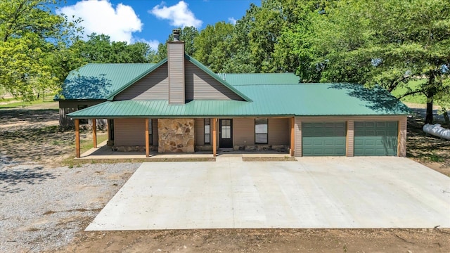 17259 Reynolds Rd, Harrisburg, AR 72432 - view of front of house featuring a porch, an attached garage, driveway, a chimney, and metal roof
