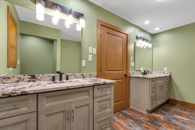 17259 Reynolds Rd, Harrisburg, AR 72432 - bathroom featuring wood finished floors, two vanities, recessed lighting, and baseboards