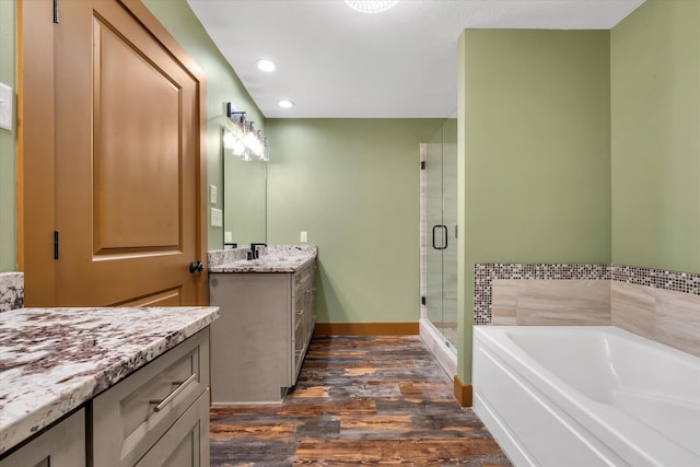17259 Reynolds Rd, Harrisburg, AR 72432 - bathroom with wood finished floors, a stall shower, a bath, vanity, and recessed lighting