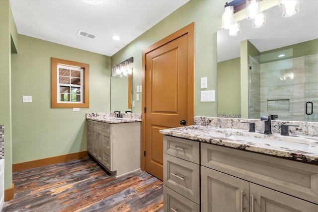 17259 Reynolds Rd, Harrisburg, AR 72432 - full bathroom with wood finished floors, a stall shower, baseboards, two vanities, and recessed lighting