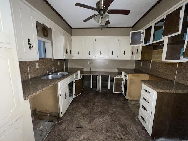 kitchen with a sink, tasteful backsplash, white cabinets, ceiling fan, and ornamental molding