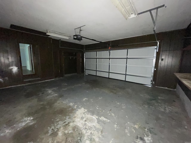garage featuring a garage door opener and wood walls