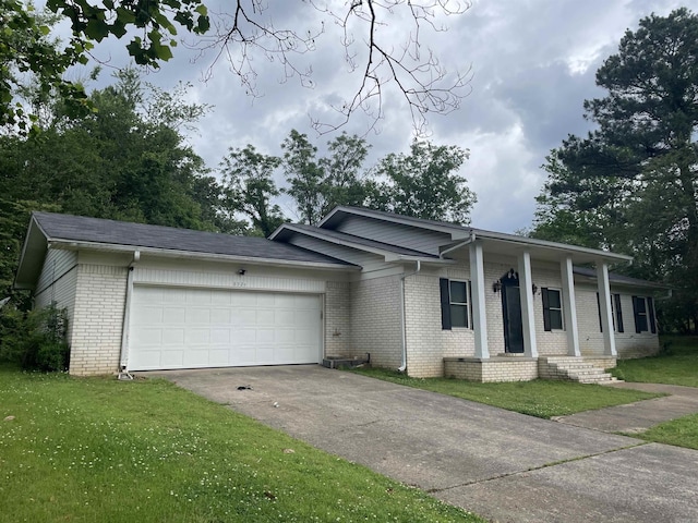 ranch-style house featuring brick siding, a garage, concrete driveway, and a front yard