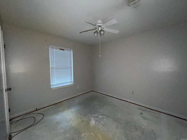empty room featuring unfinished concrete floors, ceiling fan, and baseboards