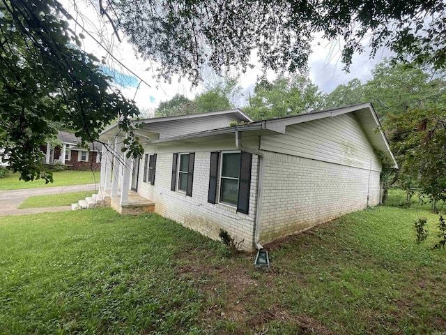 view of home's exterior featuring a lawn and brick siding