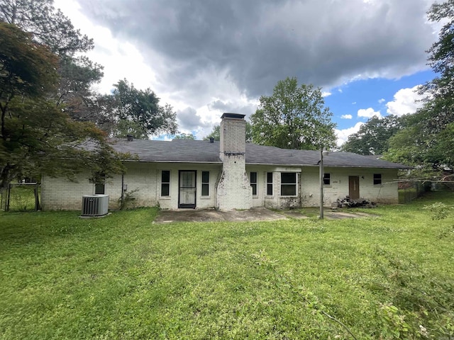 rear view of property with a chimney, brick siding, and central air condition unit