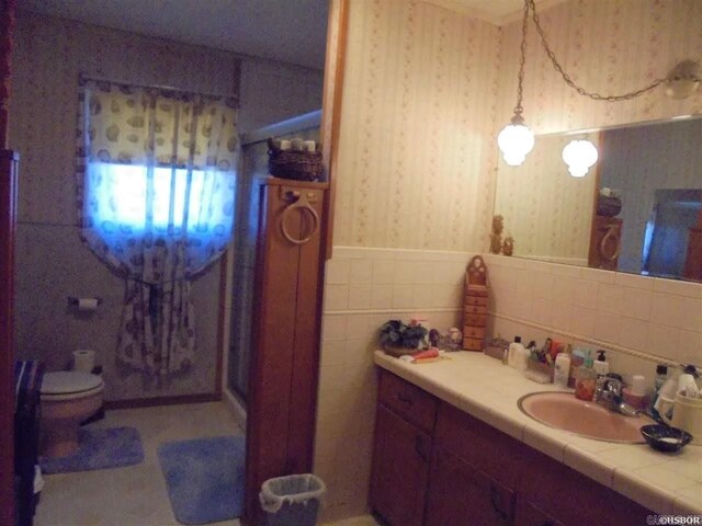 738 Pine, Amity, AR 71921 - full bathroom with wallpapered walls, a wainscoted wall, toilet, and vanity