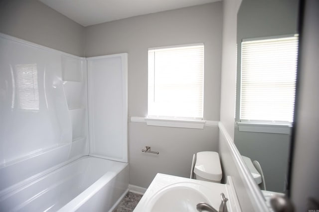 full bathroom featuring toilet, vanity, baseboards, and shower / washtub combination