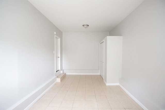 hallway featuring light tile patterned flooring and baseboards