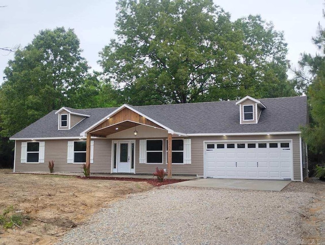 view of front facade featuring gravel driveway, an attached garage, a shingled roof, and a porch