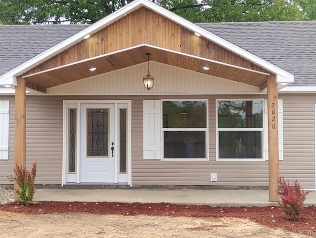 property entrance featuring roof with shingles