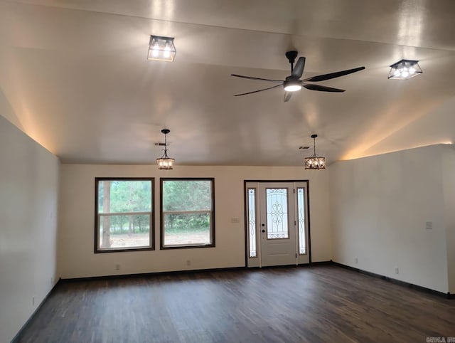 foyer featuring dark wood-style floors, healthy amount of natural light, lofted ceiling, ceiling fan, and a chandelier