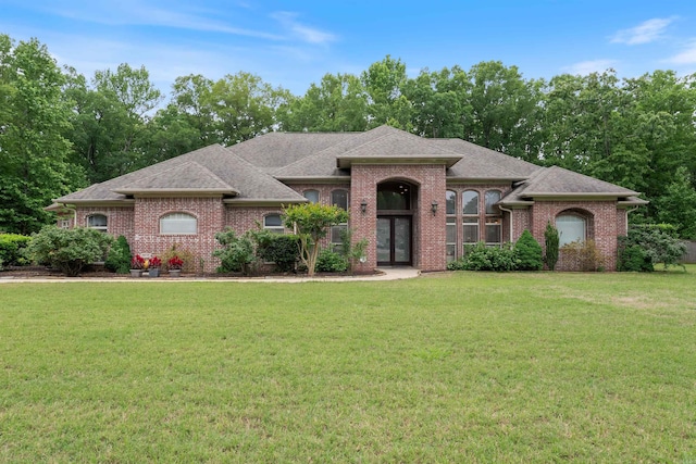 529 Enchanted Valley Ln, North Little Rock, AR 72118 - french provincial home featuring brick siding, a front yard, and a shingled roof