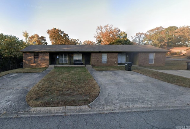 ranch-style house with brick siding, a front lawn, and concrete driveway