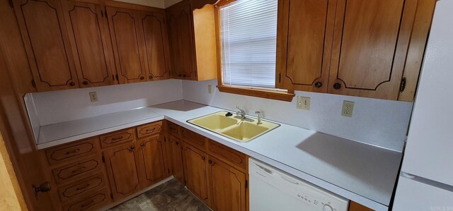 kitchen featuring white appliances, a sink, brown cabinets, and light countertops