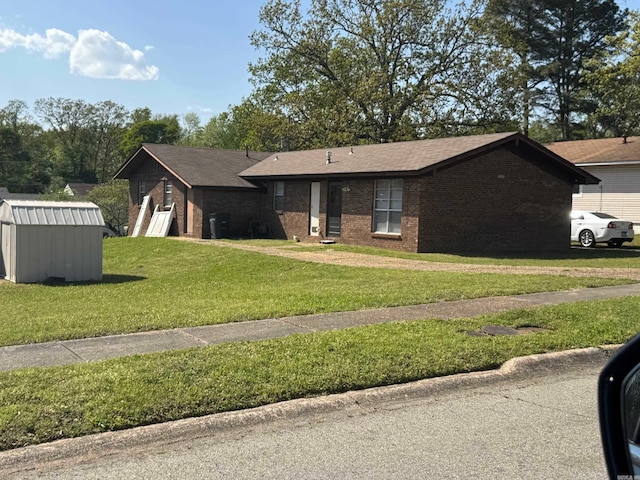 ranch-style home featuring a shed, brick siding, an outdoor structure, a front lawn, and a shingled roof