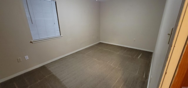 carpeted spare room featuring baseboards