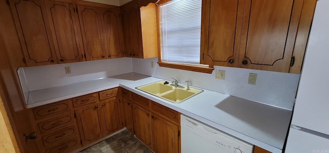 kitchen featuring white appliances, a sink, brown cabinets, and light countertops